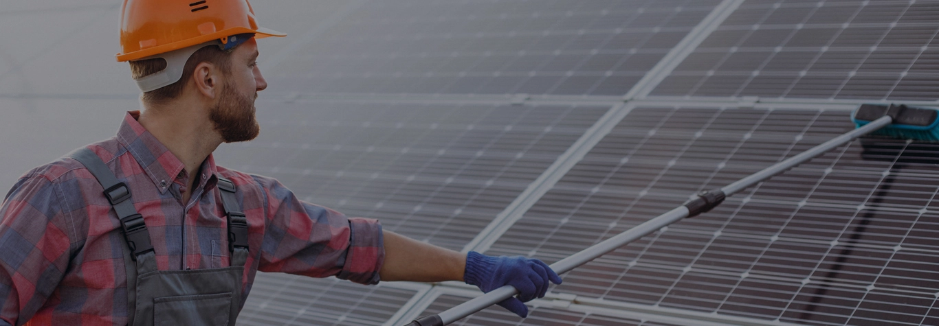 Technician rinsing solar panels with pure water